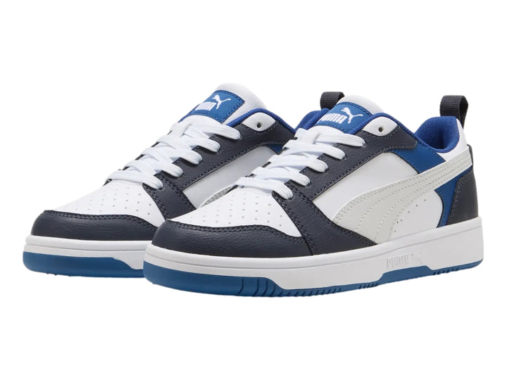 Tenis PUMA Rebound V6 Lo JR color blanco con detalles en azul y negro, diseño deportivo de corte bajo.