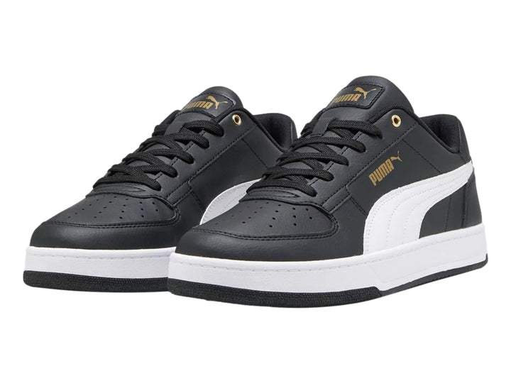 Tenis PUMA Caven 2.0 color negro con franja y suela blanca y detalles dorados.