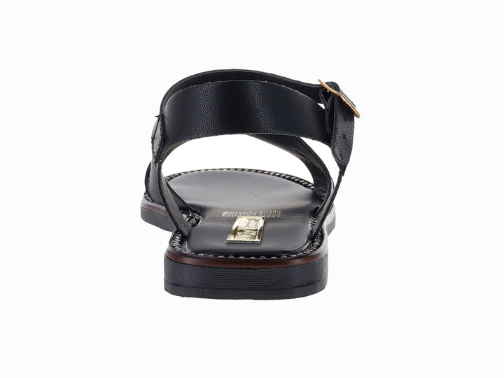 Sandalia plana color negro para Mujer con hebilla dorada y adorno frontal.