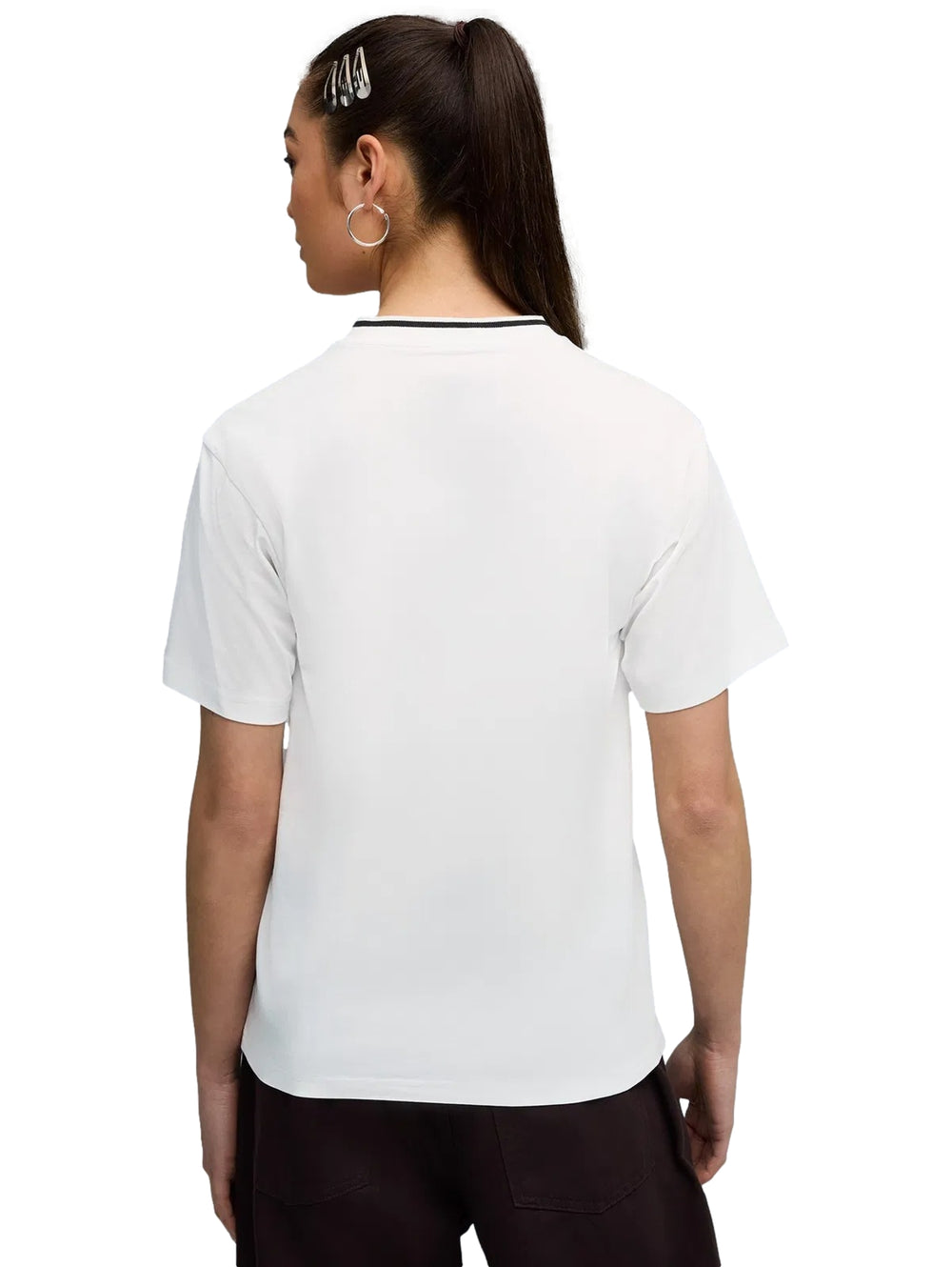 Mujer vistiendo una camiseta blanca PUMA de cuello en V con detalle negro en el cuello.
