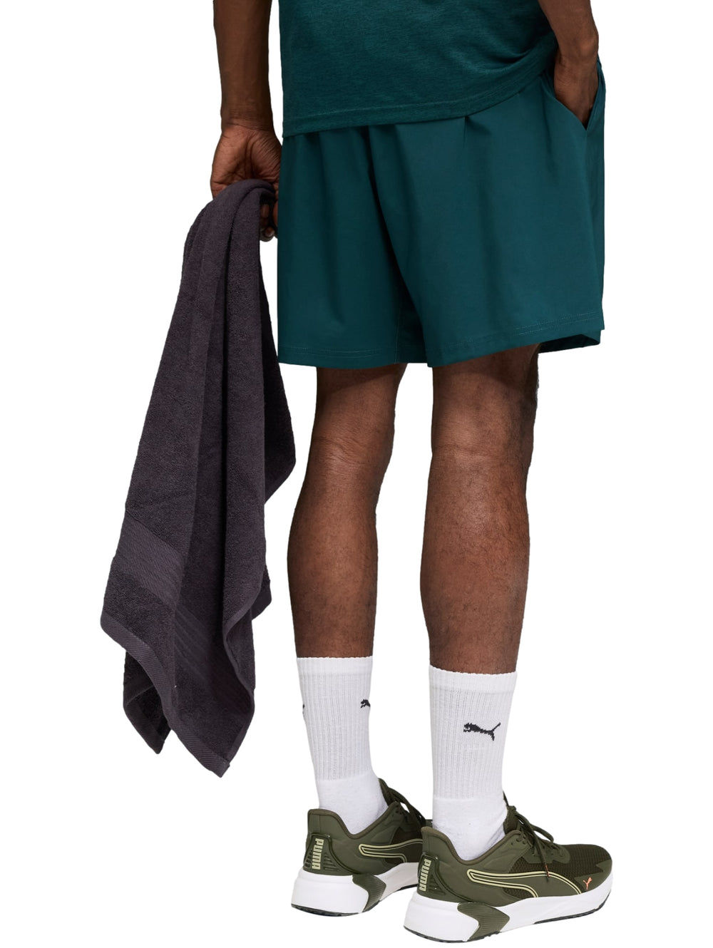 Hombre vistiendo shorts deportivos PUMA en color verde oscuro Green Terrain.
