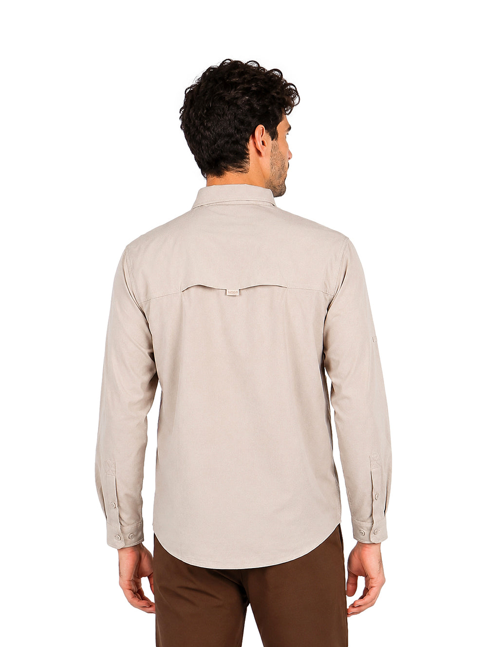 Hombre vistiendo una camisa de manga larga color arena con bolsillos frontales y tecnolog�a outdoor.