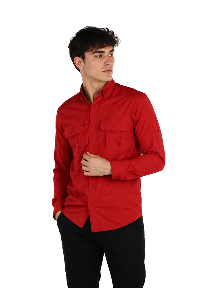 Hombre vistiendo una camisa de manga larga color rojo sangre con dos bolsillos frontales y cuello.