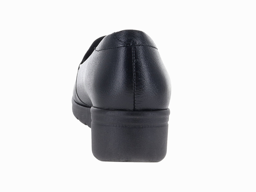 Zapato plano color negro de material sintético con suela gruesa y diseño slip-on.