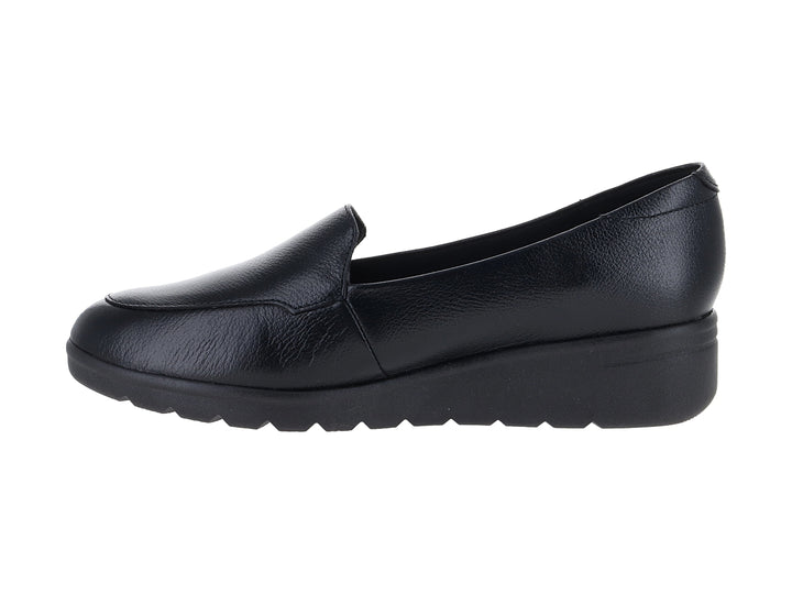 Zapato plano color negro de material sintético con suela gruesa y diseño slip-on.