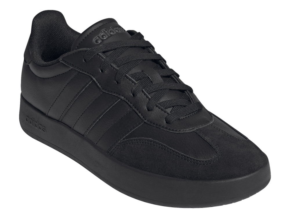 Tenis Adidas color negro con tres franjas laterales y suela plana.