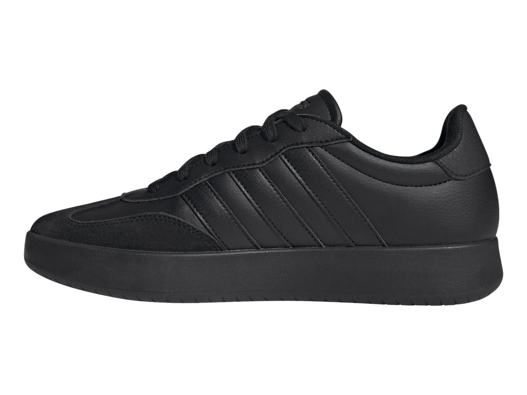 Tenis Adidas color negro con tres franjas laterales y suela plana.