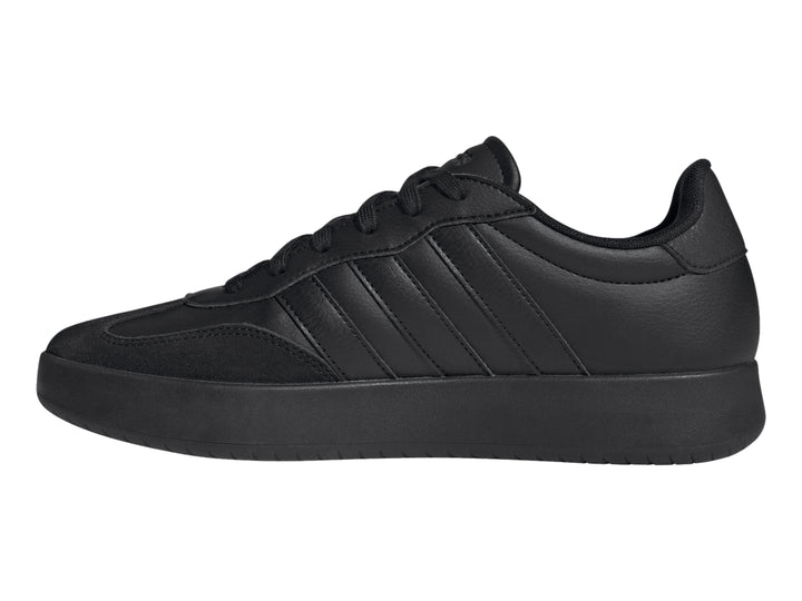 Tenis Adidas color negro con tres franjas laterales y suela plana.