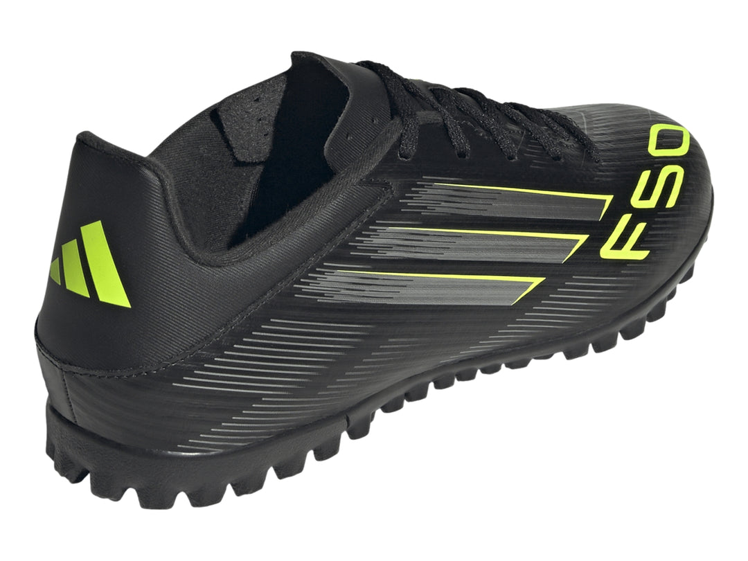 Zapato de fútbol Adidas F50 color negro con detalles en amarillo y plateado, vista lateral.