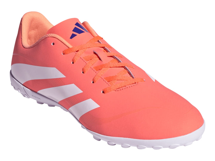 Zapato de fútbol Adidas Predator color coral con franjas blancas y suela blanca para césped sintético.