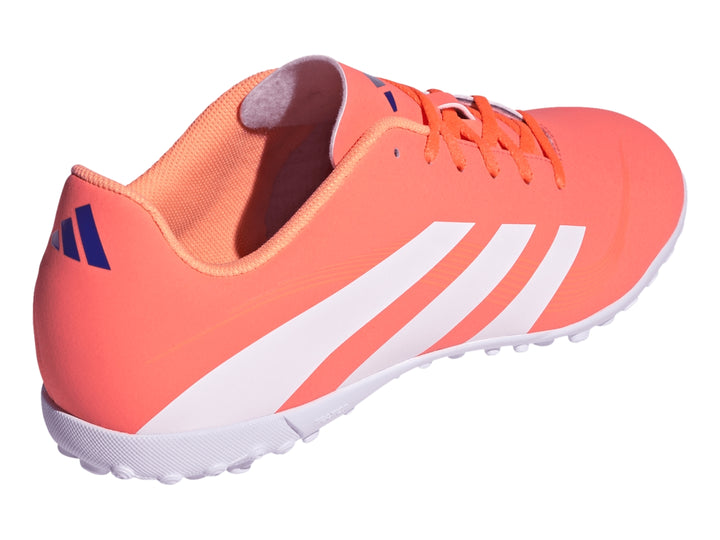Zapato de fútbol Adidas Predator color coral con franjas blancas y suela blanca para césped sintético.