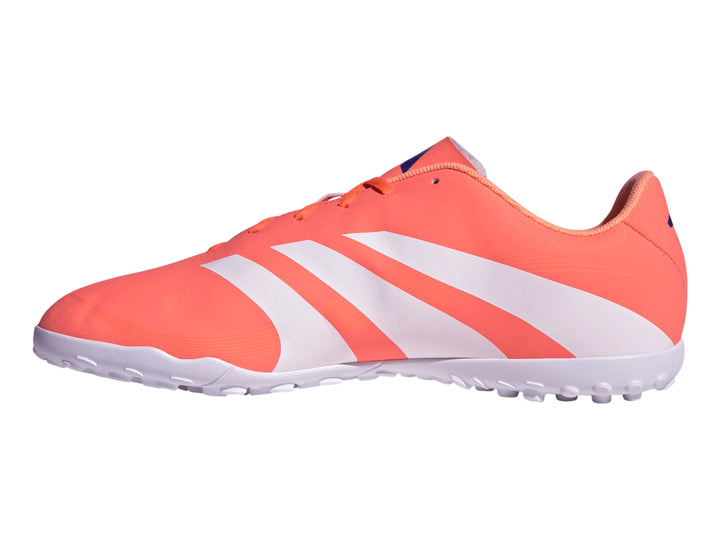 Zapato de fútbol Adidas Predator color coral con franjas blancas y suela blanca para césped sintético.