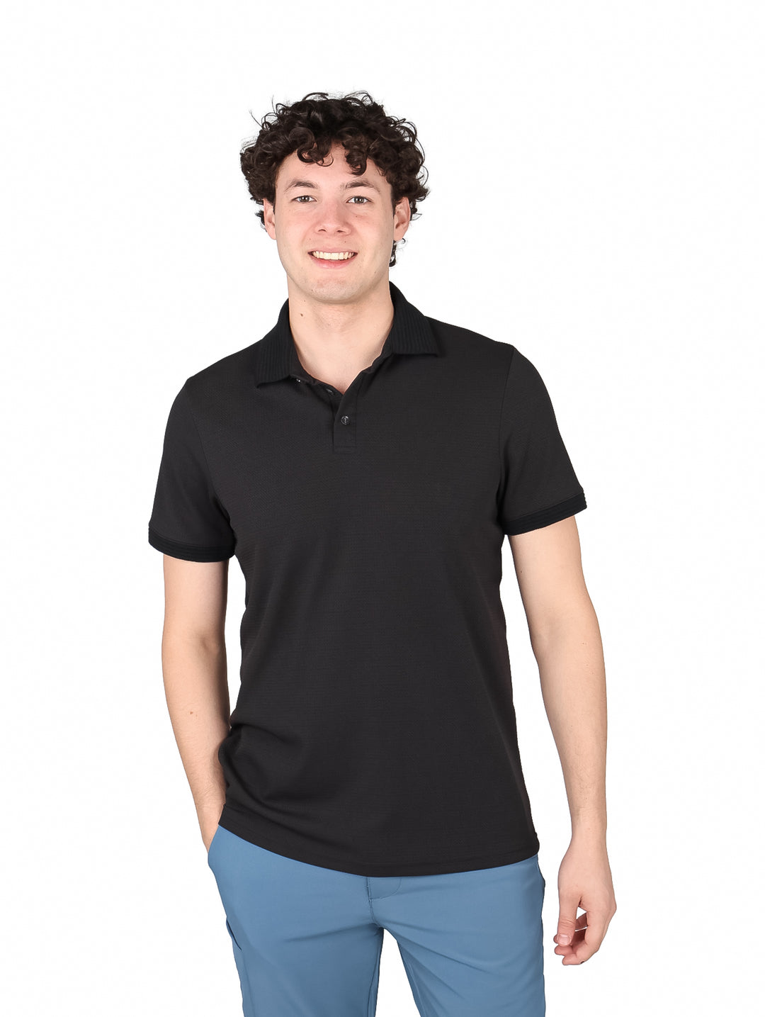 Hombre vistiendo una playera polo de color negro de manga corta.