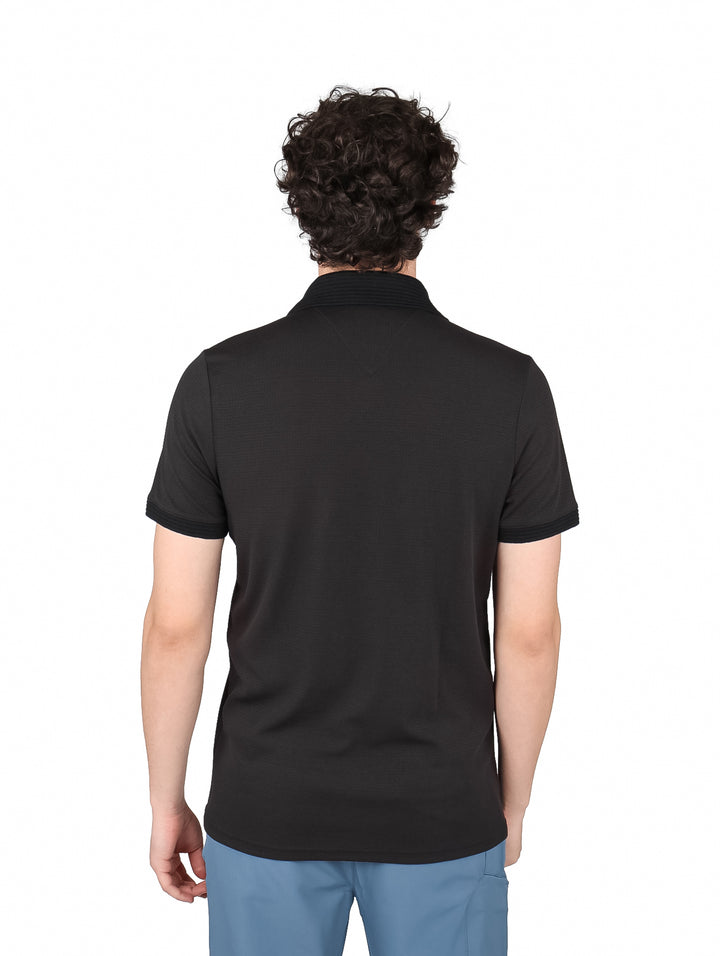 Hombre vistiendo una playera polo de color negro de manga corta.