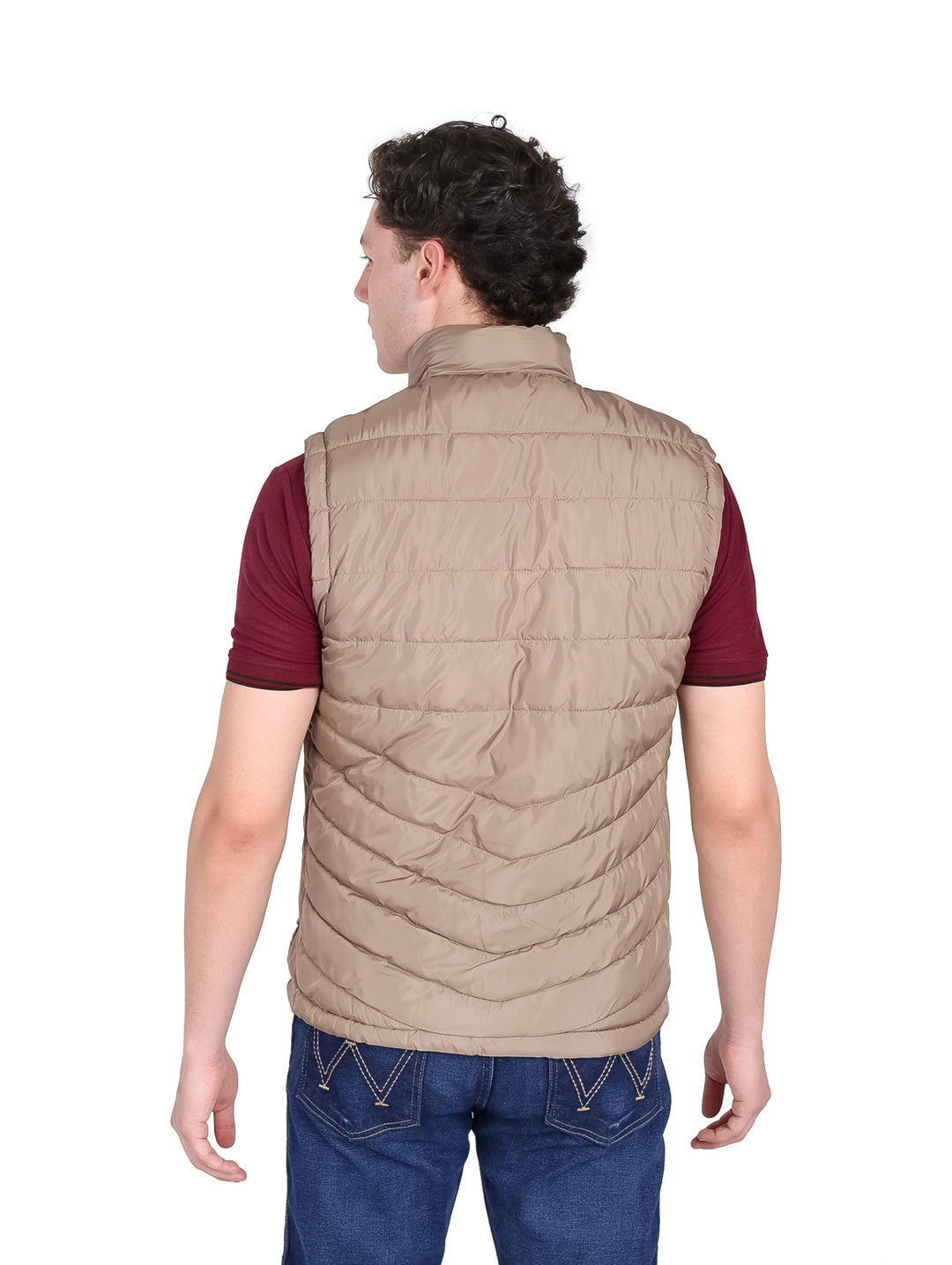 Hombre vistiendo un chaleco acolchado color beige con cierre frontal y cuello alto.