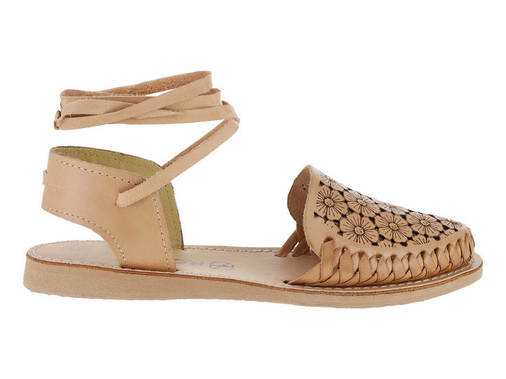 Sandalia plana color tan con diseño floral calado, frente trenzado y tiras largas para amarrar al tobillo.