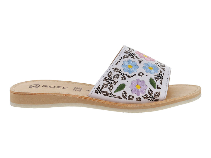 Sandalia blanca para niña con diseño de flores coloridas en la banda superior y suela beige.