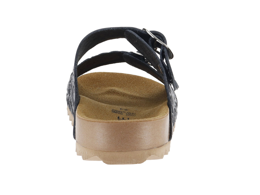 Sandalia negra con dos correas, hebillas plateadas, grabado floral y suela marrón dentada.