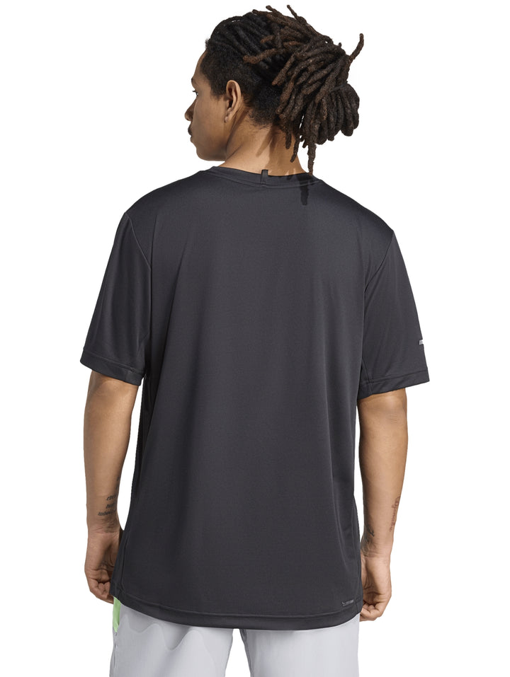Hombre vistiendo una camiseta deportiva Adidas de color negro con logo blanco en el pecho.