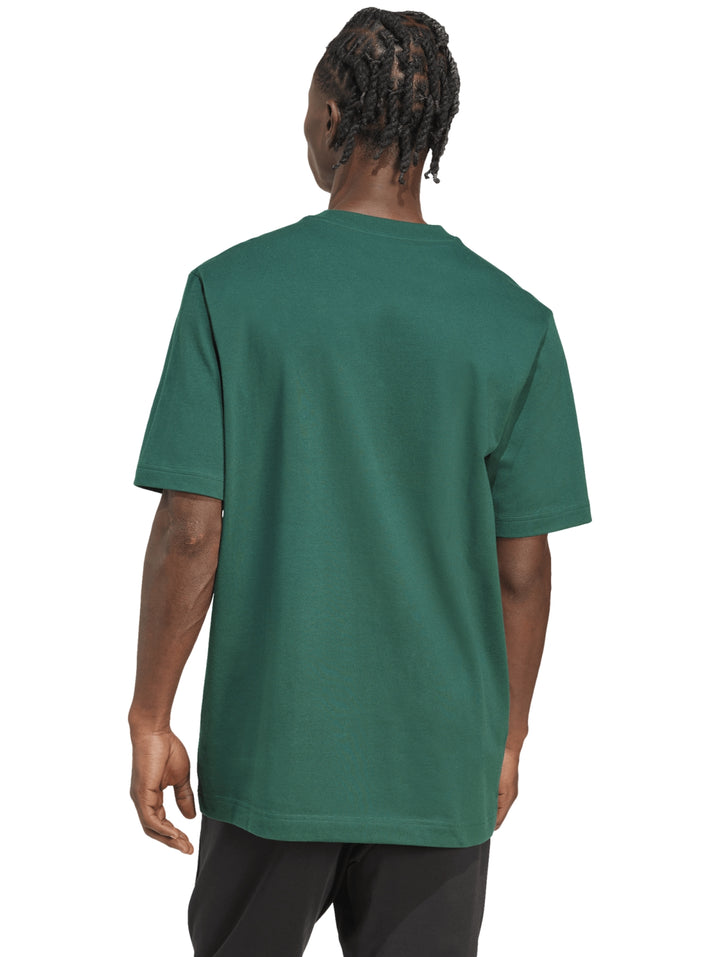 Hombre vistiendo una camiseta verde de Adidas con un gráfico colorido en el pecho.