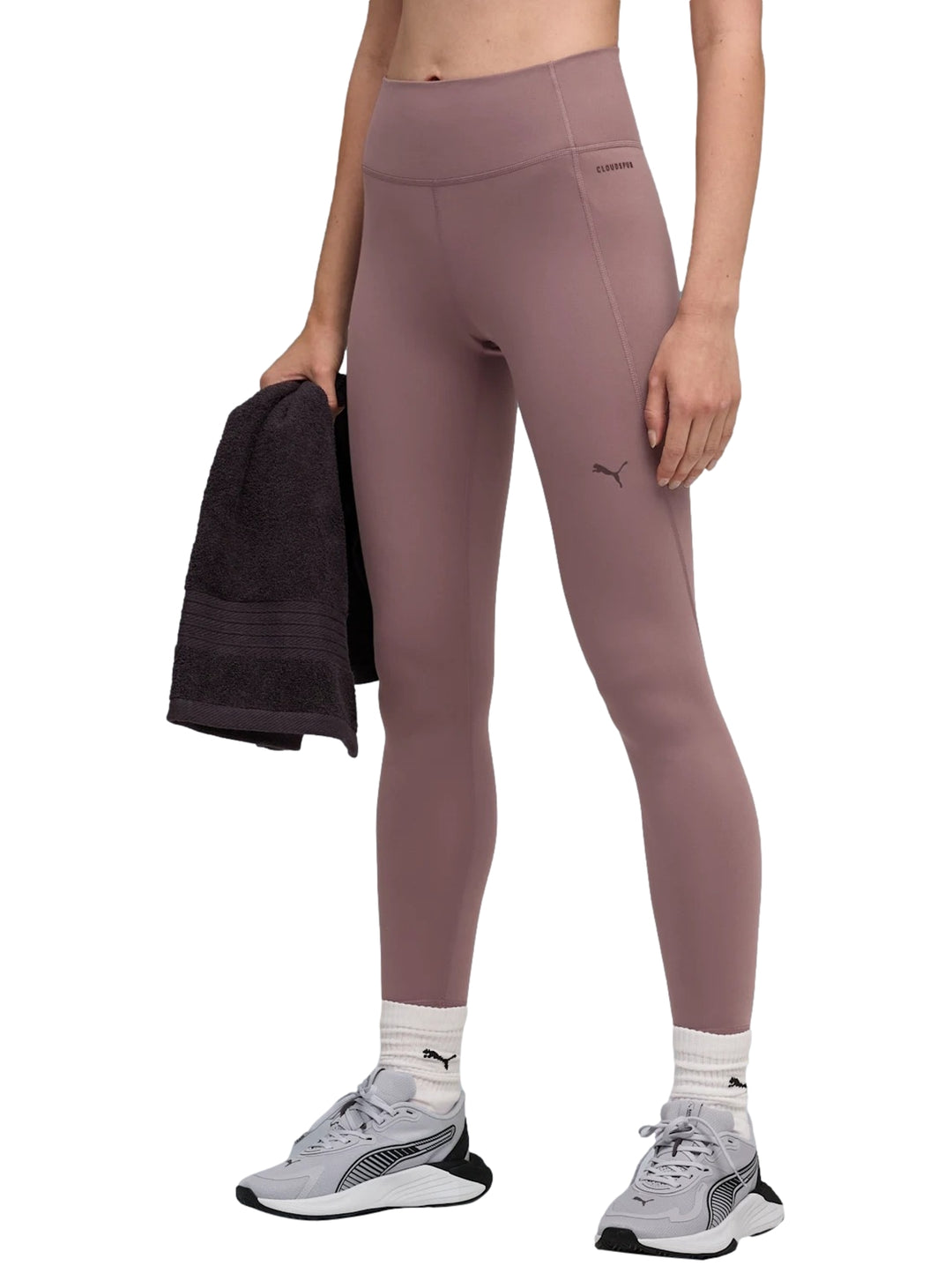 Mujer vistiendo leggings deportivos PUMA de color raisin con cintura alta.