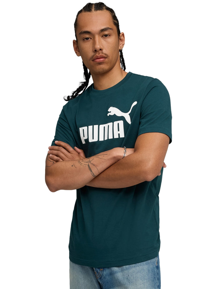 Hombre vistiendo una playera PUMA de color verde terrain con logotipo blanco en el pecho.
