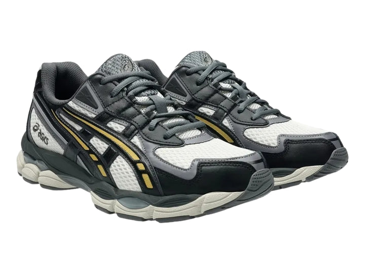 Tenis ASICS GEL-NYC 2055 en colores gris humo y obsidiana con detalles amarillos y suela amortiguada.