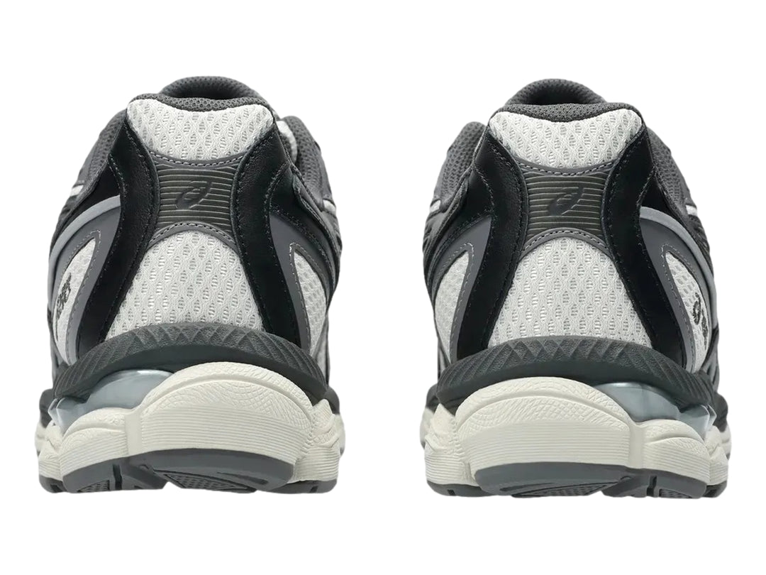 Tenis ASICS GEL-NYC 2055 en colores gris humo y obsidiana con detalles amarillos y suela amortiguada.
