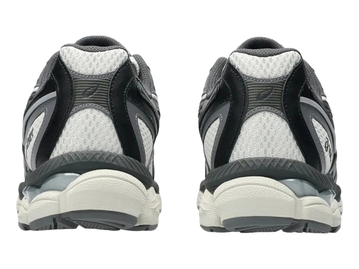 Tenis ASICS GEL-NYC 2055 en colores gris humo y obsidiana con detalles amarillos y suela amortiguada.