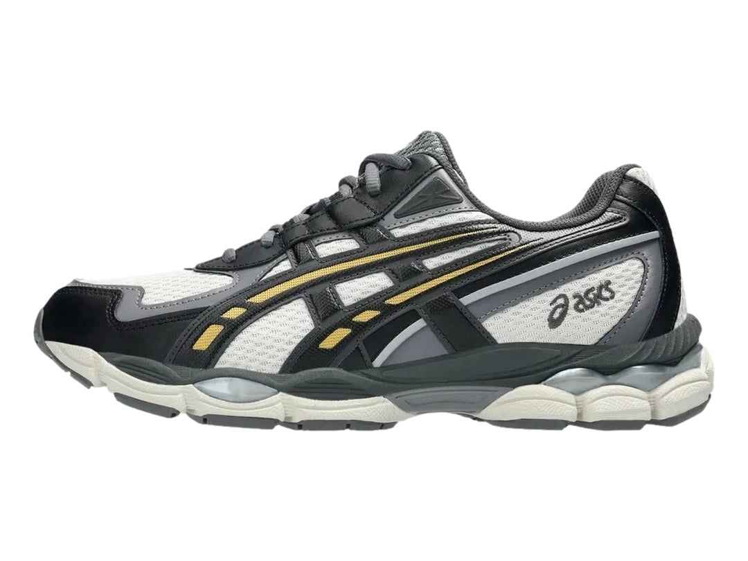Tenis ASICS GEL-NYC 2055 en colores gris humo y obsidiana con detalles amarillos y suela amortiguada.