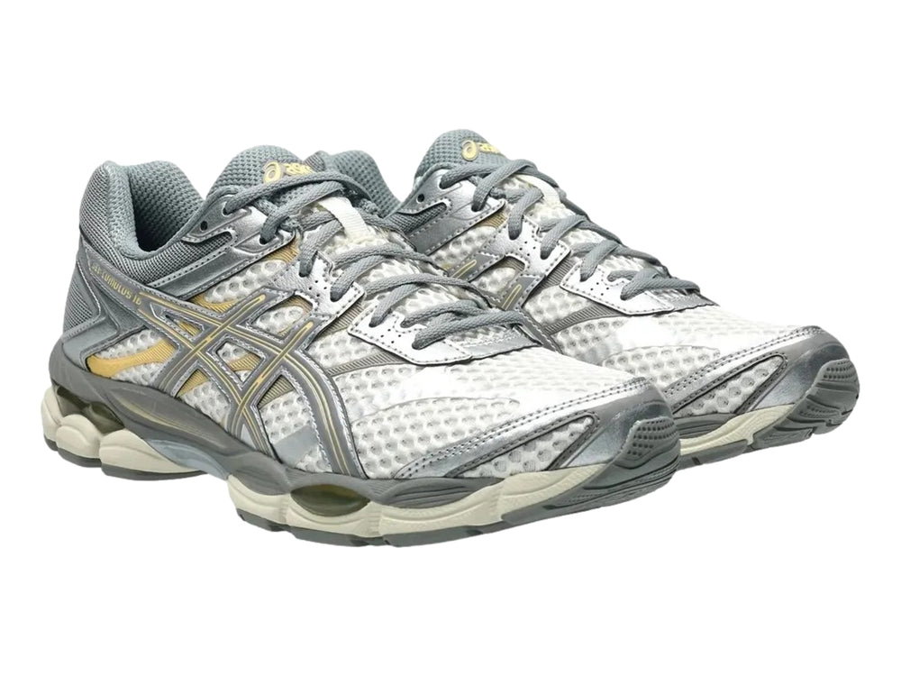 Tenis deportivos ASICS Gel-Cumulus 16 en color gris y crema con detalles en malla y suela amortiguada.