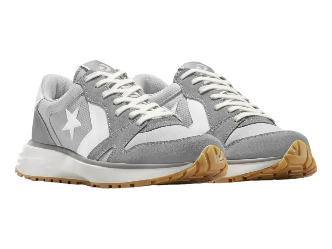 Tenis Converse Omni Trainer color gris y blanco con suela de goma color miel.