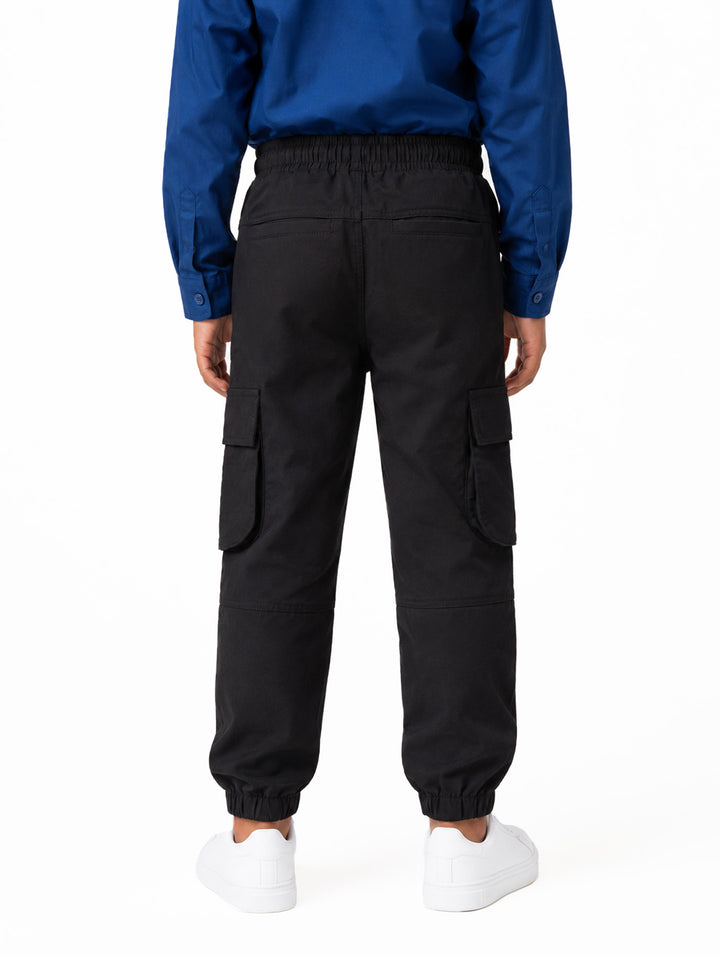 Pantalón cargo jogger color negro para niño con bolsillos laterales y cintura ajustable.