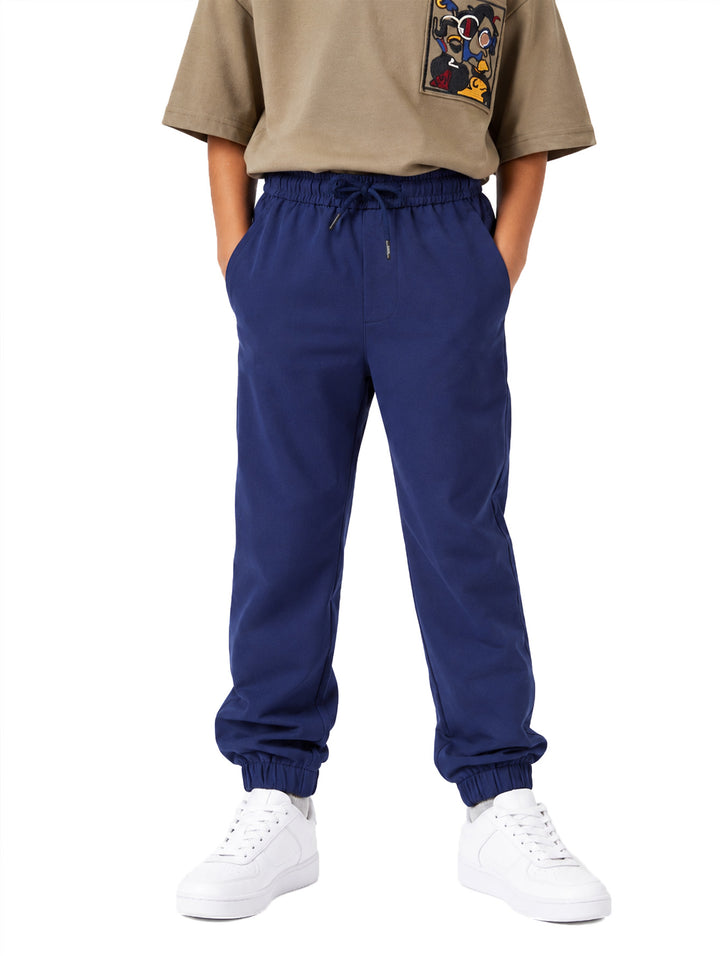 Pantalón azul marino para niño con cintura ajustable de jareta y puños en los tobillos.