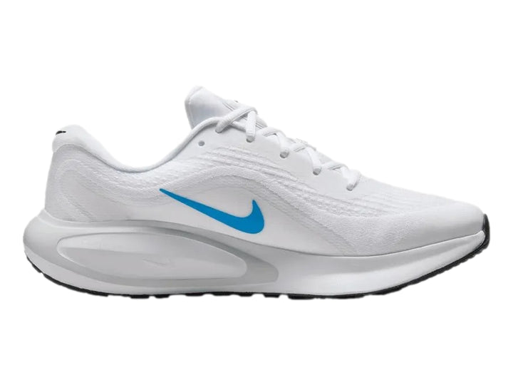 Tenis Nike Journey Run color blanco con logotipo azul y suela blanca y negra.