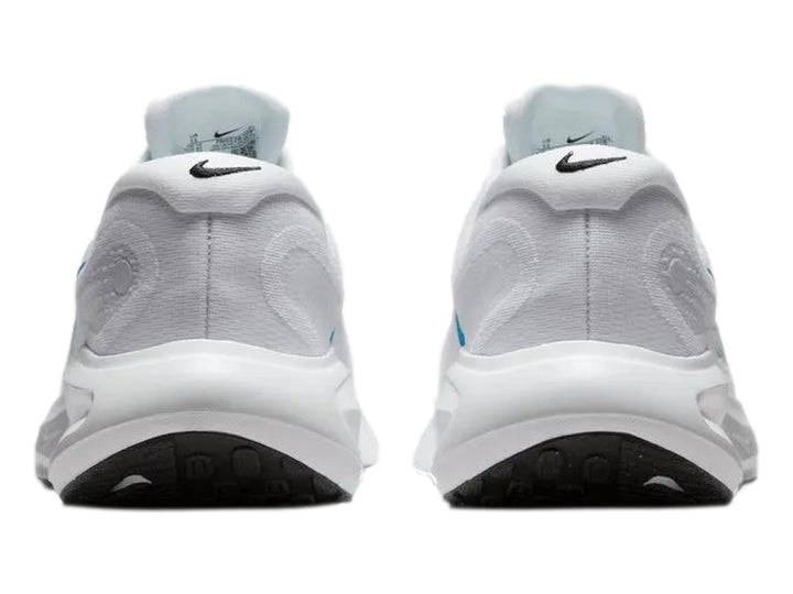 Tenis Nike Journey Run color blanco con logotipo azul y suela blanca y negra.