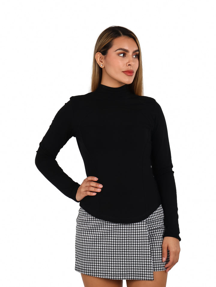 Mujer vistiendo una blusa negra ajustada de manga larga y cuello alto.