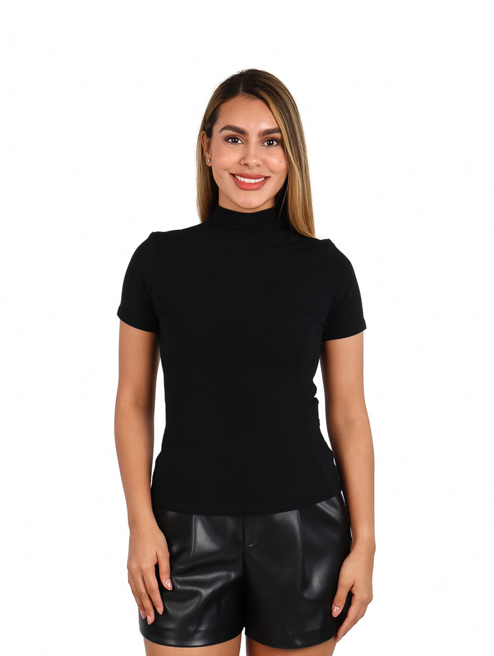 Mujer vistiendo una blusa negra de manga corta y cuello alto, combinada con shorts negros.