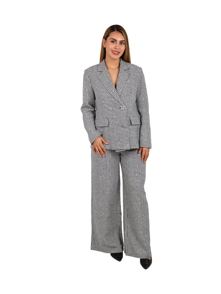 Mujer vistiendo un conjunto de blazer y pantalón ancho a cuadros en color blanco y negro.
