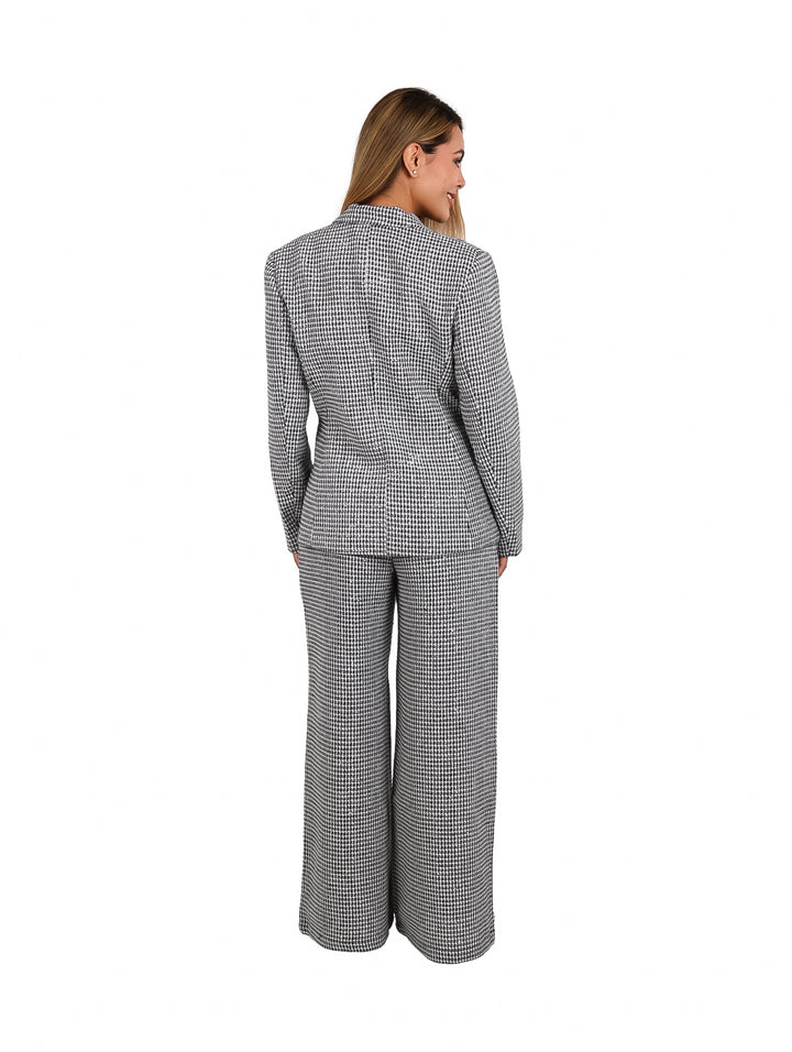 Mujer vistiendo un conjunto de blazer y pantalón ancho a cuadros en color blanco y negro.