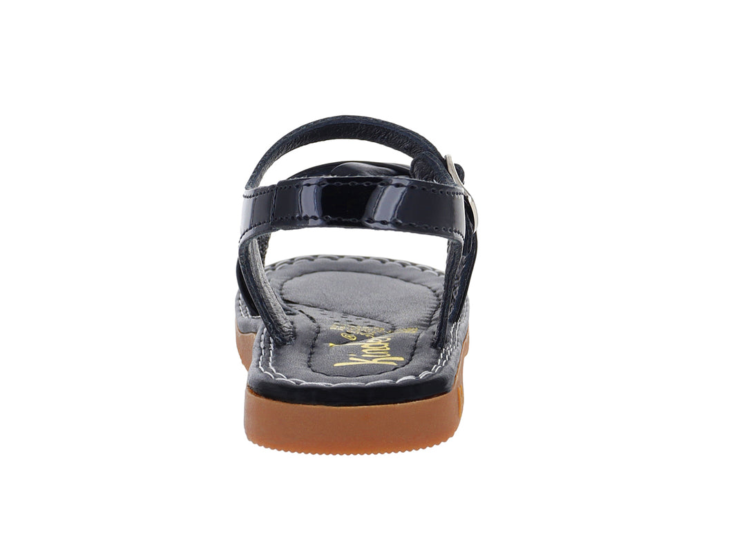 Sandalia de charol negro para niña con moño decorativo y suela color café.