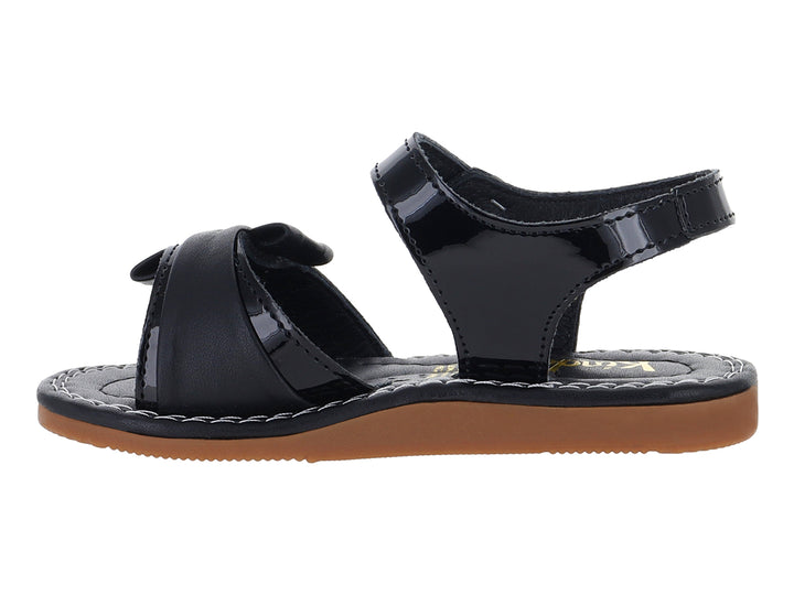Sandalia de charol negro para niña con moño decorativo y suela color café.