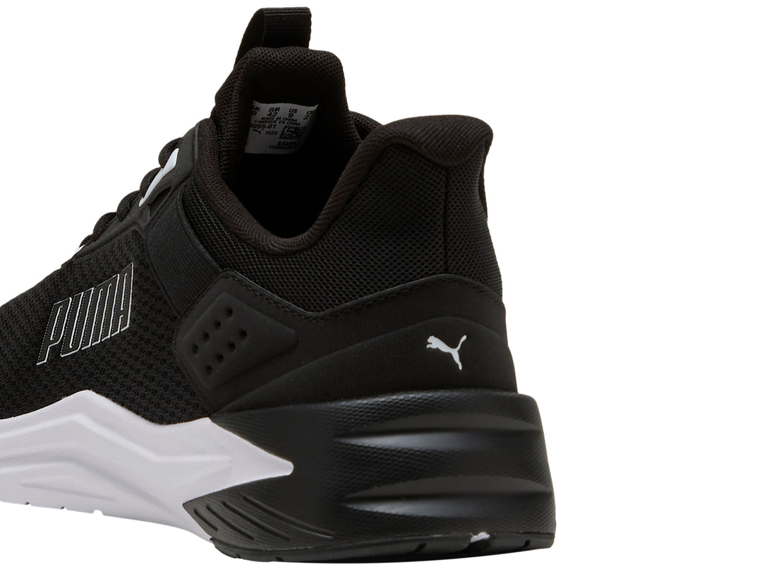 Tenis deportivos PUMA color negro con suela blanca, vista lateral.