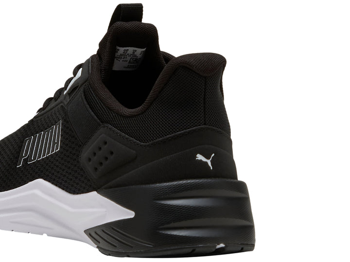 Tenis deportivos PUMA color negro con suela blanca, vista lateral.