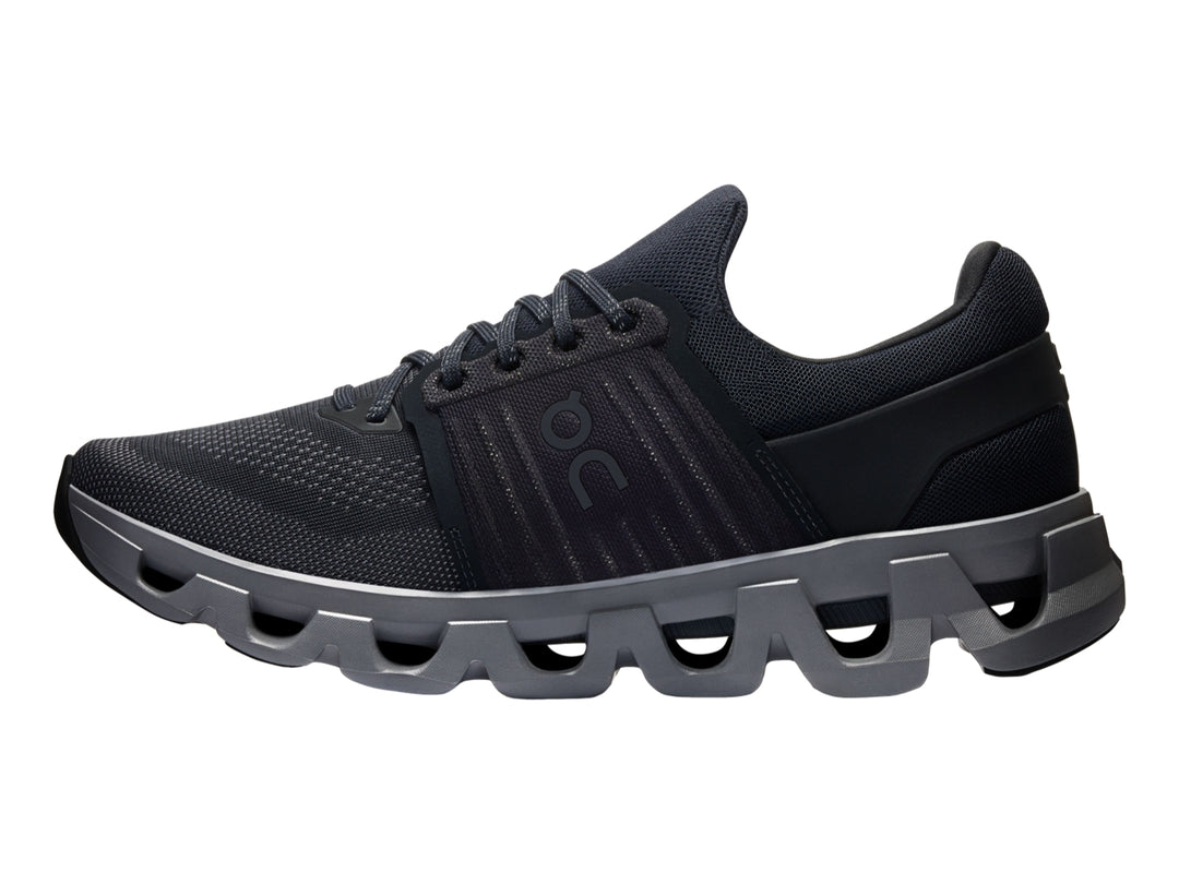 Tenis deportivos On Cloud color negro con suela gris oscuro y diseño de amortiguación característica.
