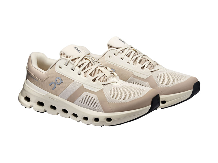 Tenis deportivos On Cloud en tonos beige y blanco con suela amortiguada característica.