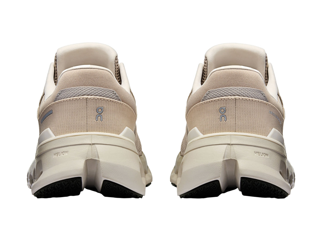 Tenis deportivos On Cloud en tonos beige y blanco con suela amortiguada característica.