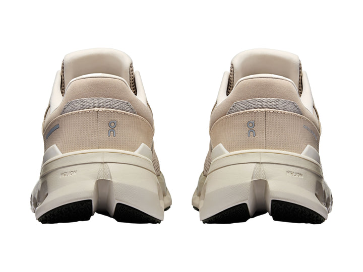 Tenis deportivos On Cloud en tonos beige y blanco con suela amortiguada característica.