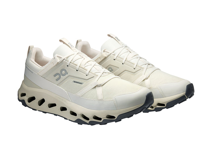 Tenis deportivos On Cloud color marfil con suela amortiguada y diseño moderno.