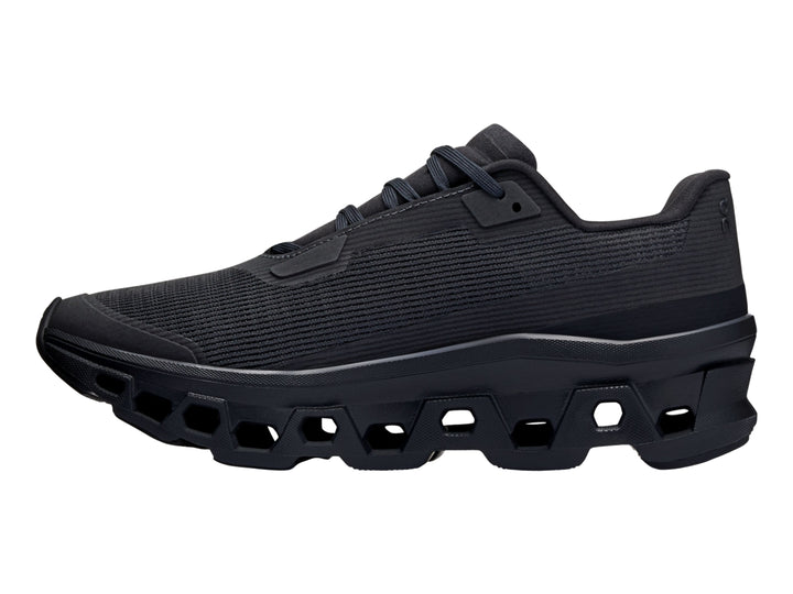 Tenis deportivos On Cloud en color negro total con suela gruesa y diseño de malla.